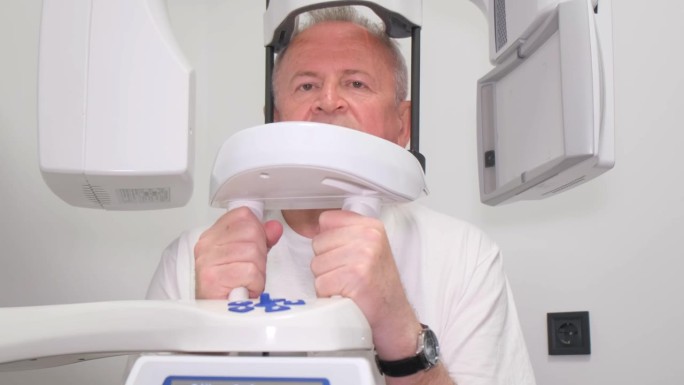 牙科x光机与头测量孔，一个老人拍他的脸。
