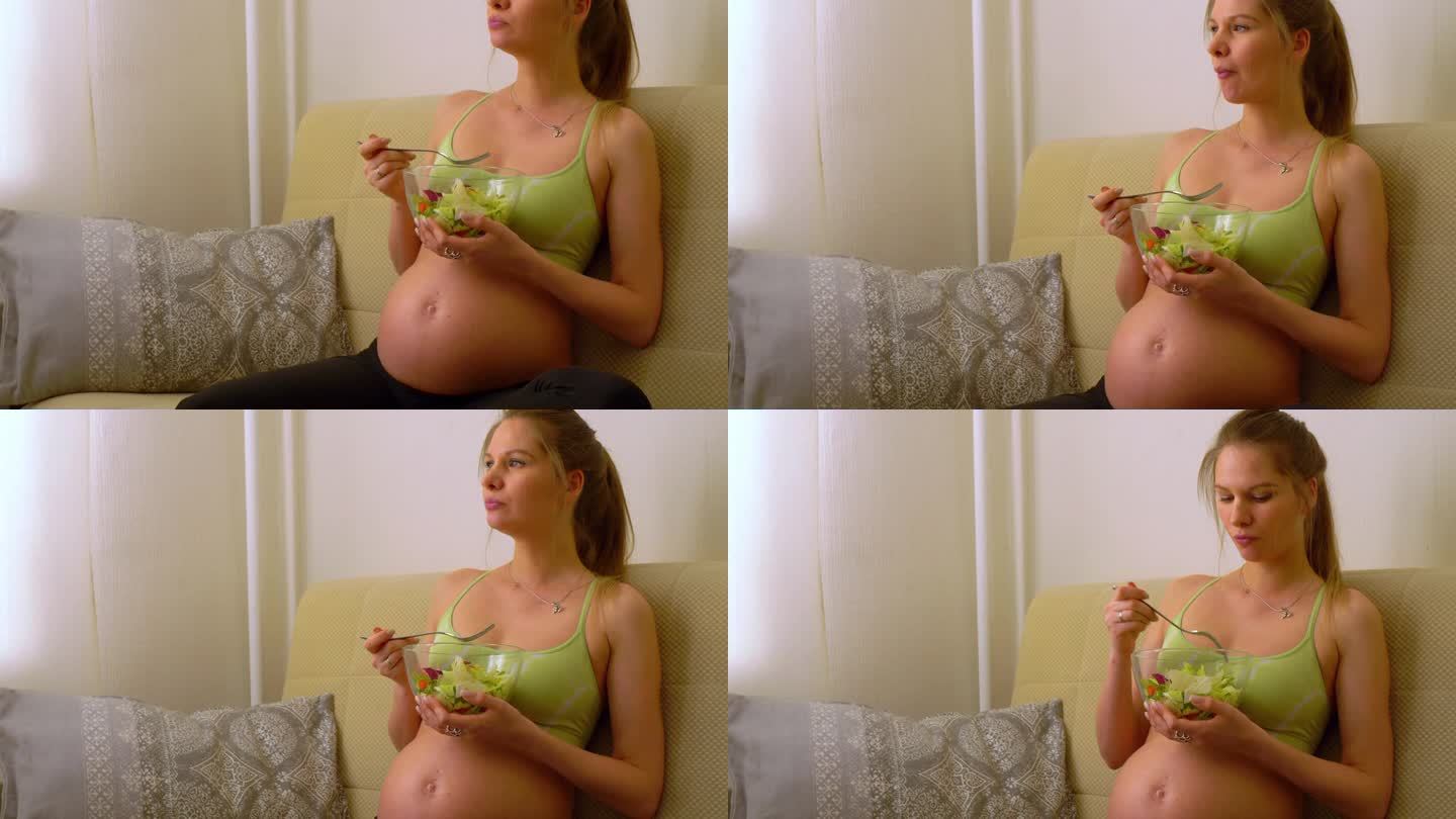年轻的孕妇为了不发胖，正在吃新鲜的沙拉