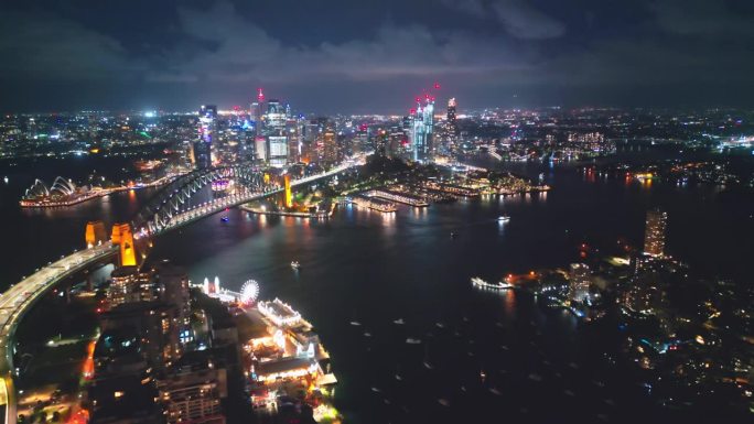鸟瞰实时镜头以上悉尼海港大桥，环形码头，歌剧院和悉尼大胆港办公室和豪华大楼组在夜间，澳大利亚