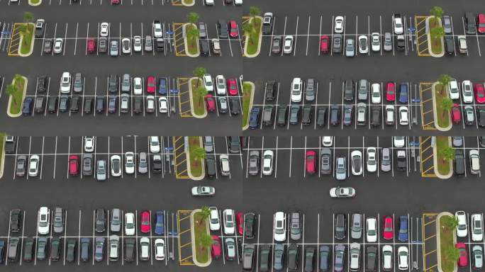 停车场停着许多汽车。超级购物中心的大型停车场，有车辆停放和方向的线条和标记