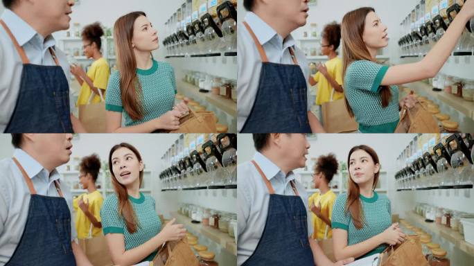 亚洲男店主向美丽的亚洲女顾客推荐零食，帮助女顾客做决定，而非洲女顾客在补充店挑选其他产品。
