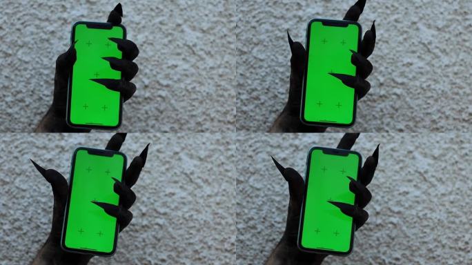 僵尸用爪子抓着智能手机绿屏色度键万圣节概念广告