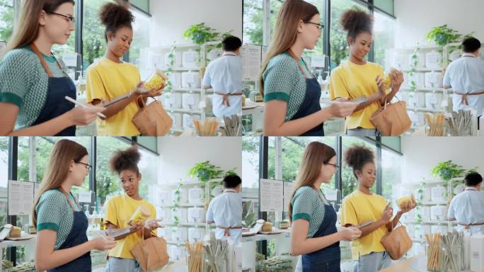 亚洲女销售代表向穿着黄色t恤的非洲女顾客推荐小罐子里的零食，而一名不认识的男子在补充店检查其他产品的