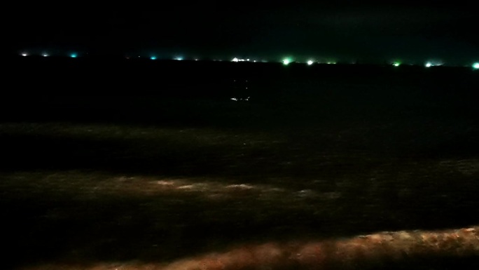 海滩，夜晚的海浪，水面上的倒影