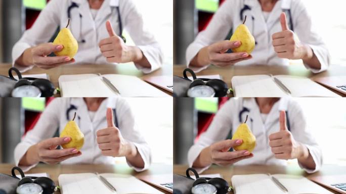 双手医生拿着水果，手指向上做手势