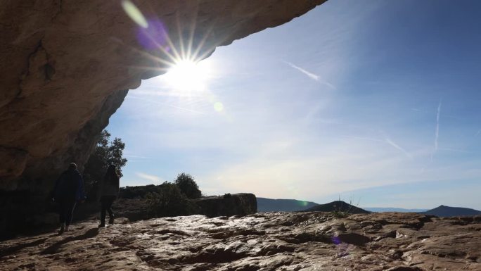 阿姨和侄女在山洞里徒步旅行，星光灿烂的太阳照耀着他们。