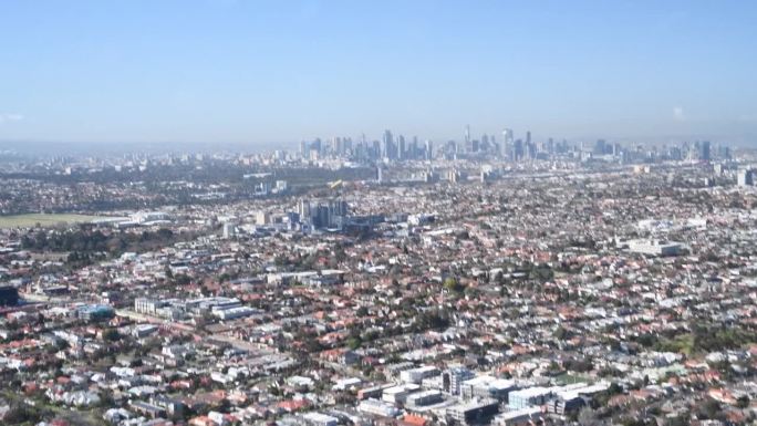 从直升机上鸟瞰墨尔本天际线的慢动作，澳大利亚。晴天的城市全景