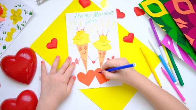 孩子自制贺卡。小女孩用纸做了两个有微笑和爱心的冰淇淋，作为母亲节、生日或情人节的礼物。工艺美术概念。