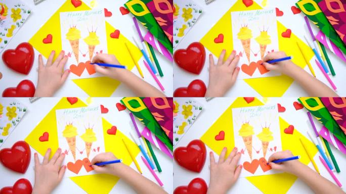 孩子自制贺卡。小女孩用纸做了两个有微笑和爱心的冰淇淋，作为母亲节、生日或情人节的礼物。工艺美术概念。