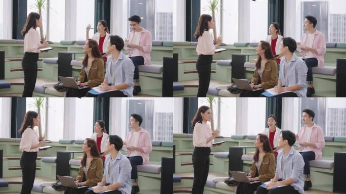 在办公室的会议室里，中年亚洲女商人站在她的同事面前，展示她的商业战略想法，分享她提高商业利润的经验。