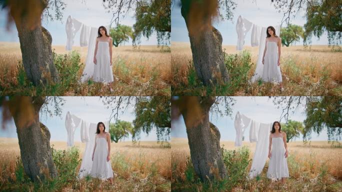 一名农村妇女在野外自然花园里晒衣服。夏日女孩在黑麦地里摆姿势