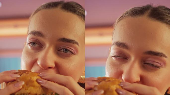 垂直屏幕:跟踪一个正在家里享受美味汉堡的女人的慢动作肖像。一个快乐的女人，她点了快餐，对高品质表示赞