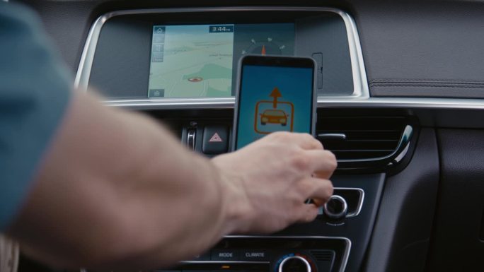 将带有汽车共享应用程序的手机粘贴到汽车手机座上