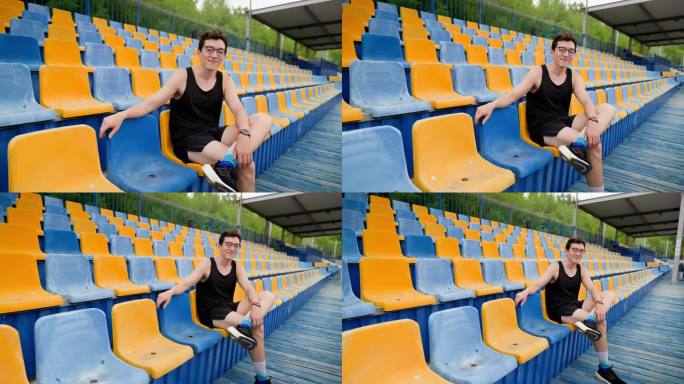 一个亚洲人坐在体育领奖台上看着镜头，镜头移动流畅，中景