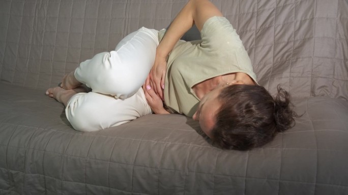 孕妇在沙发上感到疼痛的宫缩。