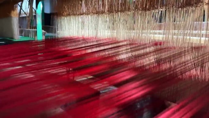 传统手工木制织布机上的彩色线。动感的丝线:传统手工织布机的延时拍摄