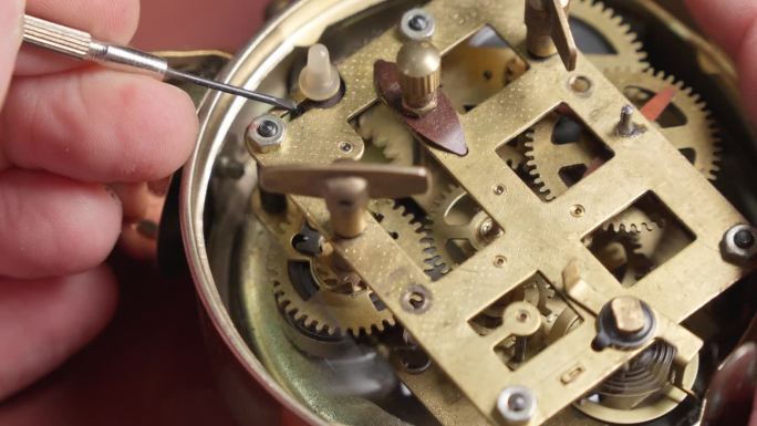 师傅修理古董表的时钟机构。