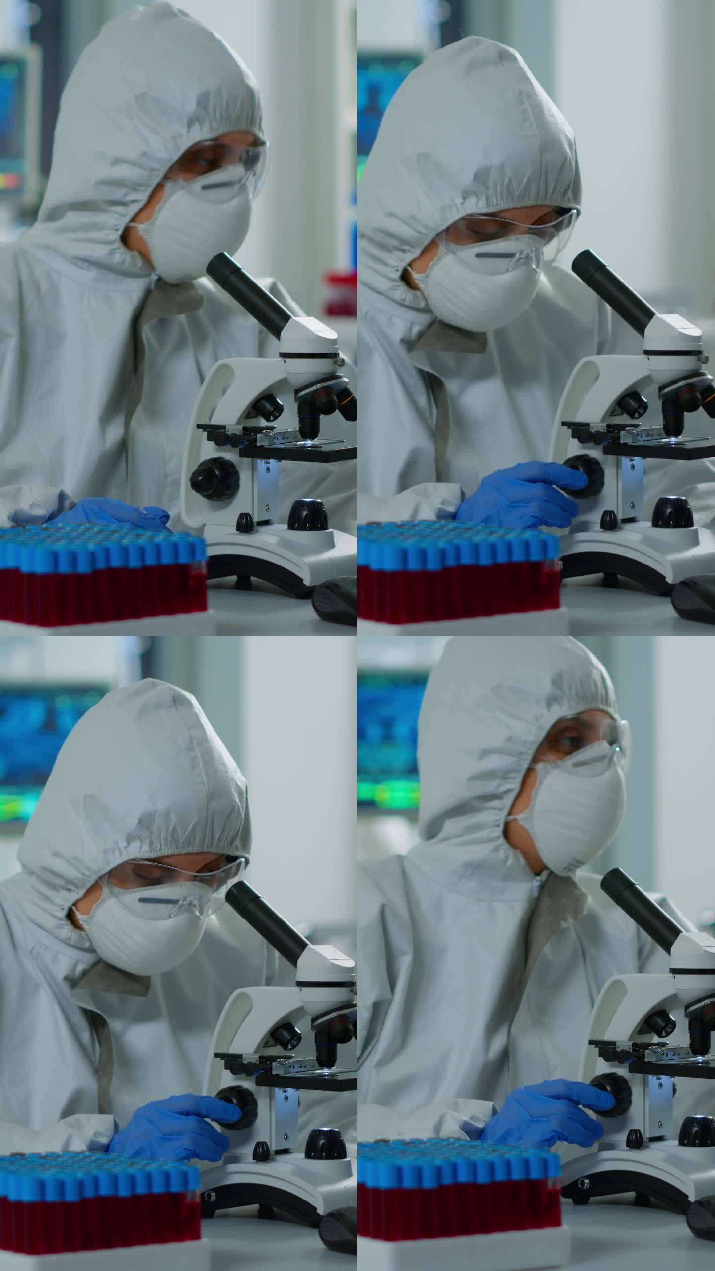 垂直视频:穿着防护服的女科学家在实验室使用现代显微镜工作