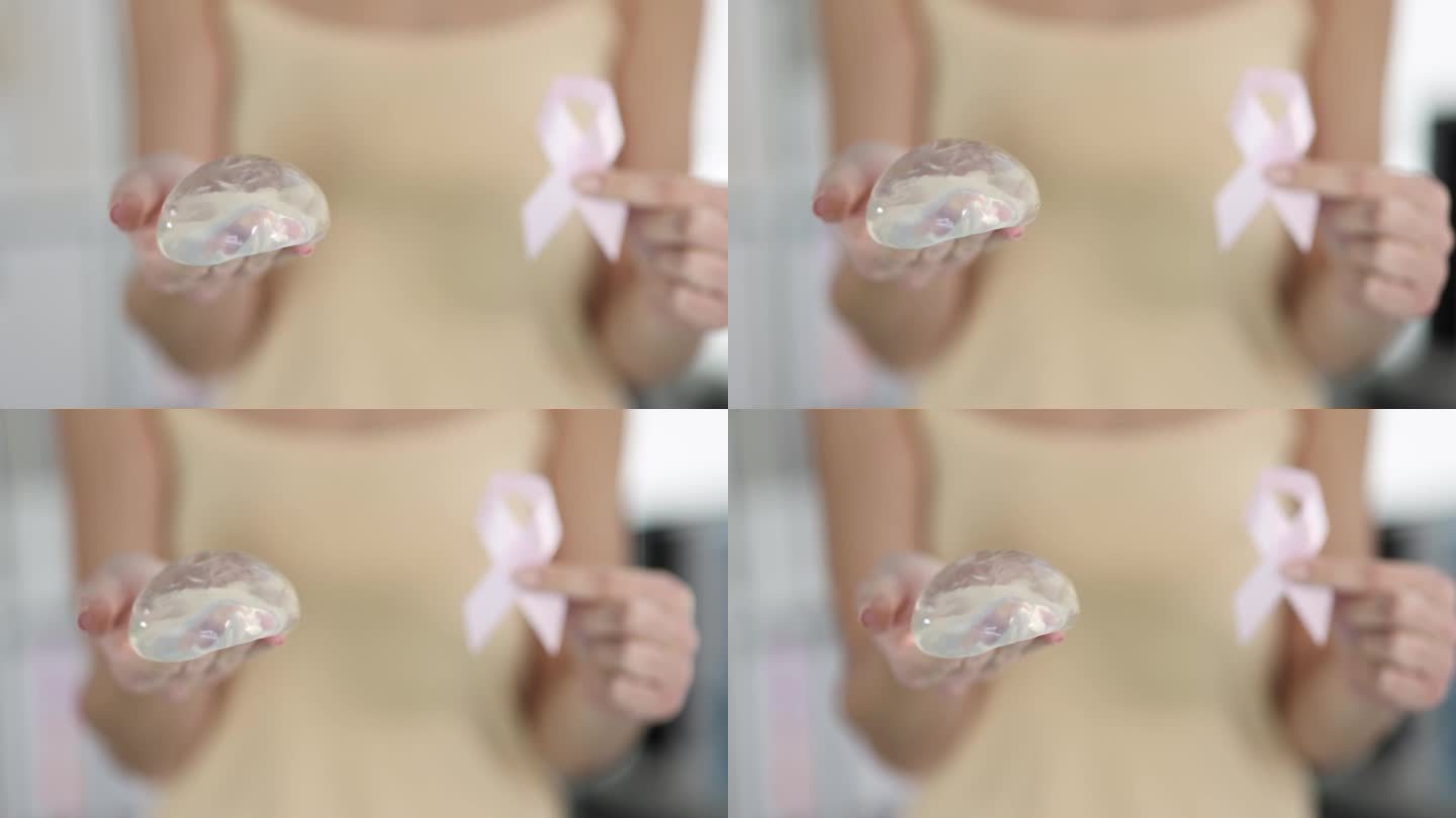 女病人拿着硅胶乳房植入物和粉色丝带，4k电影慢动作特写