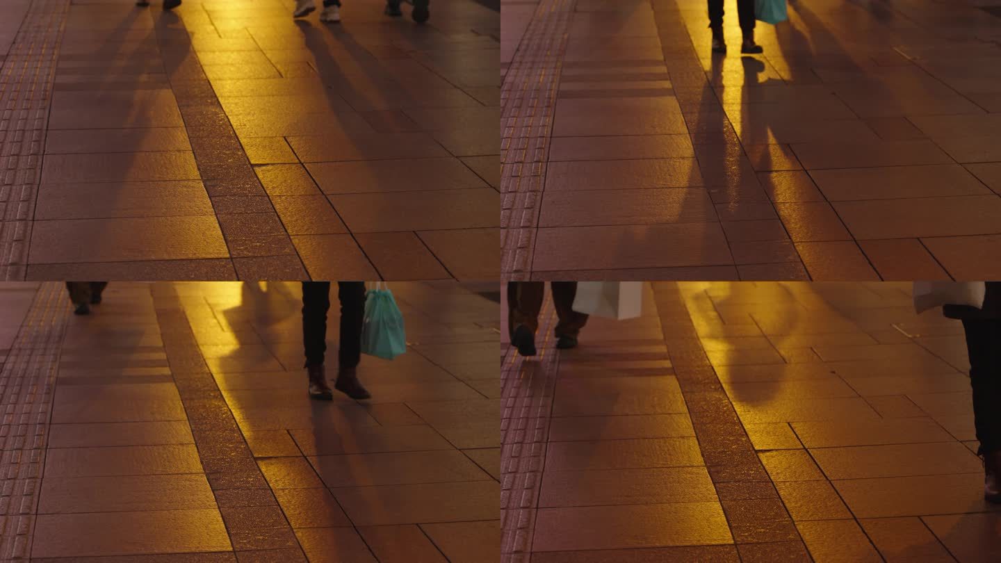 暖色灯光下路人行走的脚步