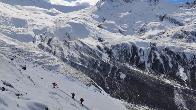 攀登乌库楚雪山的登山者大雪中徒步行进