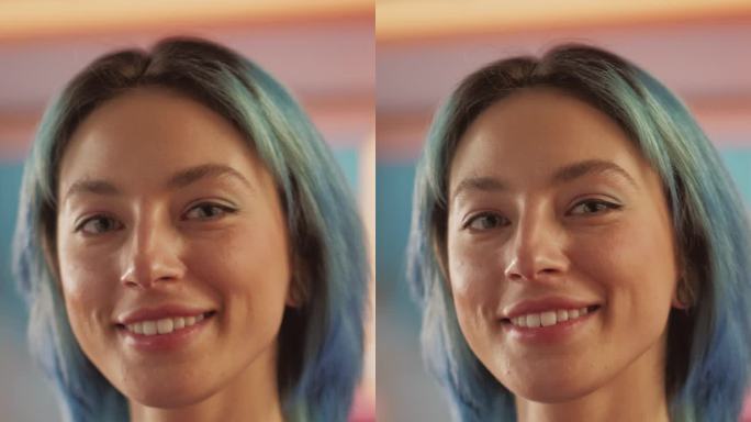 垂直屏幕:蓝色头发的美丽时尚女性的慢动作肖像，抬头看着镜头，迷人地微笑。成功的年轻女子在五颜六色的公