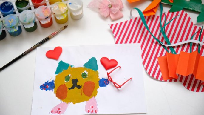 小朋友画可爱的小猫、爱心、用纸做工艺品。手工概念的生日，母亲节或情人节。教育。灵感和想象力