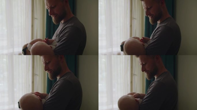 男子爸爸双手抱着婴儿，摇晃着哄孩子入睡