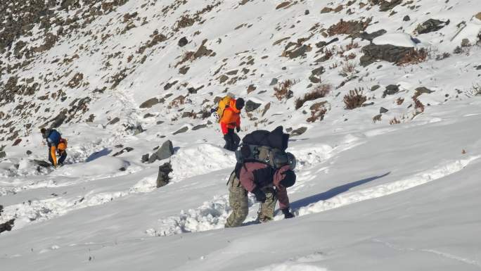 攀登乌库楚雪山的登山者大雪中徒步行进