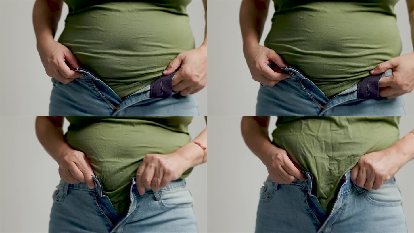 胖女人拉裤子拉链，腹部赘肉，不健康的生活方式