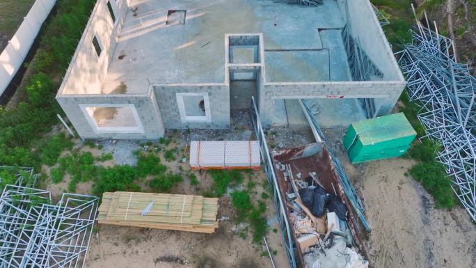 新佛罗里达住宅的建筑工地。鸟瞰图，未完成的私人住宅框架，砖混墙准备安装木制屋顶梁。工业建筑工地