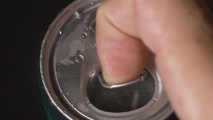 身份不明的男子打开铝制啤酒罐的慢镜头特写