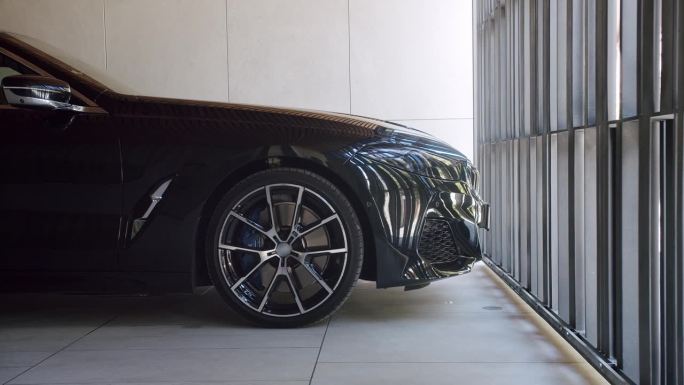 黑色汽车的侧面视图在现代车库与打开自动大门