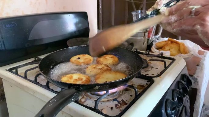 一名妇女正在烹饪墨西哥食品中的油炸土豆饼