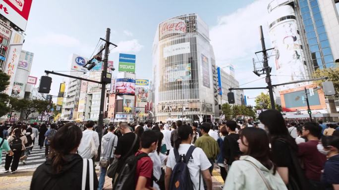涩谷城市生活的实时剪辑，日本东京的旅游景点地标。日本人山人海，游客走在拥挤的十字广场。汽车交通运输。