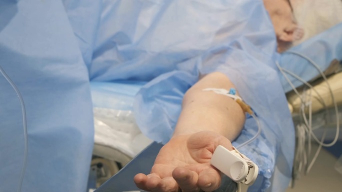 手术中的病人手臂上插着静脉导管。手术