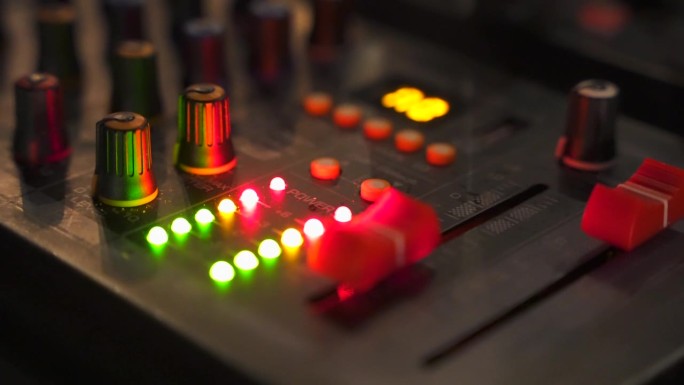近距离的绿色和红色LED指示灯音频信号水平在输出上的混音dj控制台。音乐产业的演变