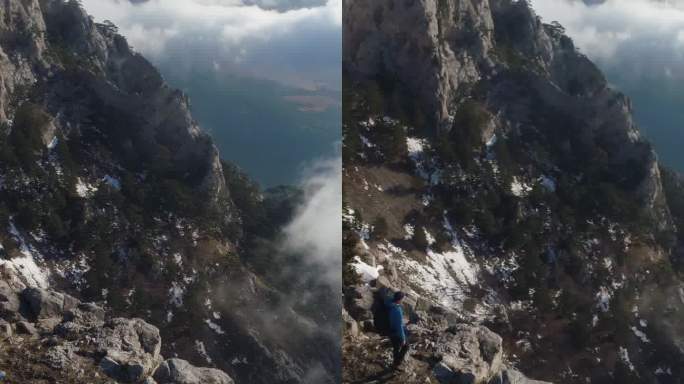 背着背包的徒步旅行者站在陡峭的山崖边。垂直视频