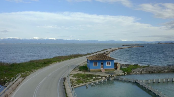 科罗尼西亚著名道路上传统希腊蓝屋的无人机鸟瞰图，背景是山脉