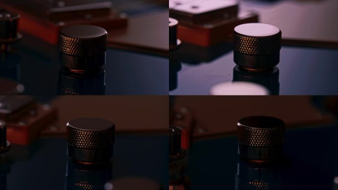 吉他音量或音调旋钮或电位器的近景。相机绕着工件旋转到轨道上。反射移动在控制旋钮和蓝色吉他表面。背景是
