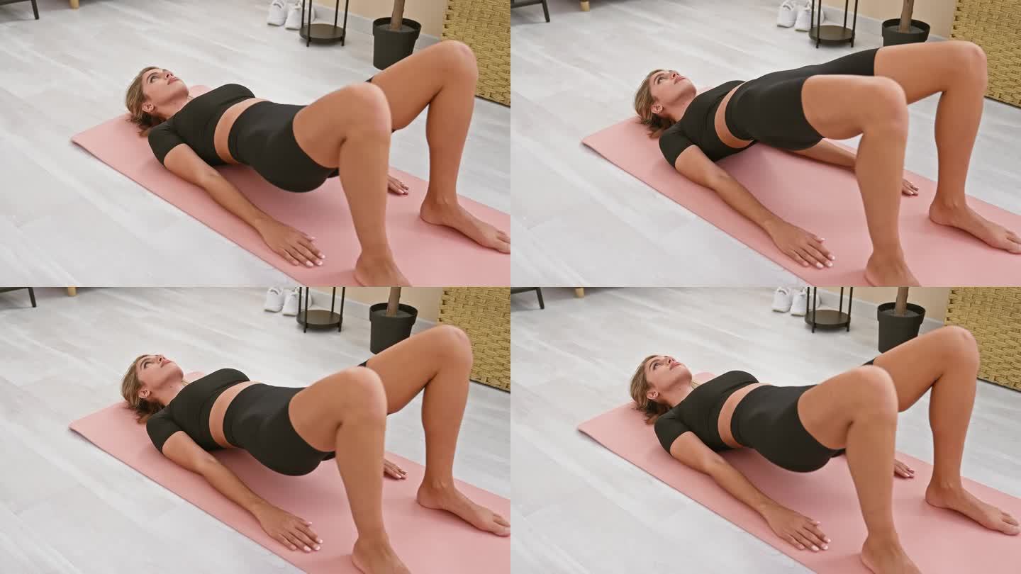 健康的年轻金发女子在她宁静的家庭客厅里躺在室内的垫子上，通过瑜伽锻炼强烈地训练腰椎