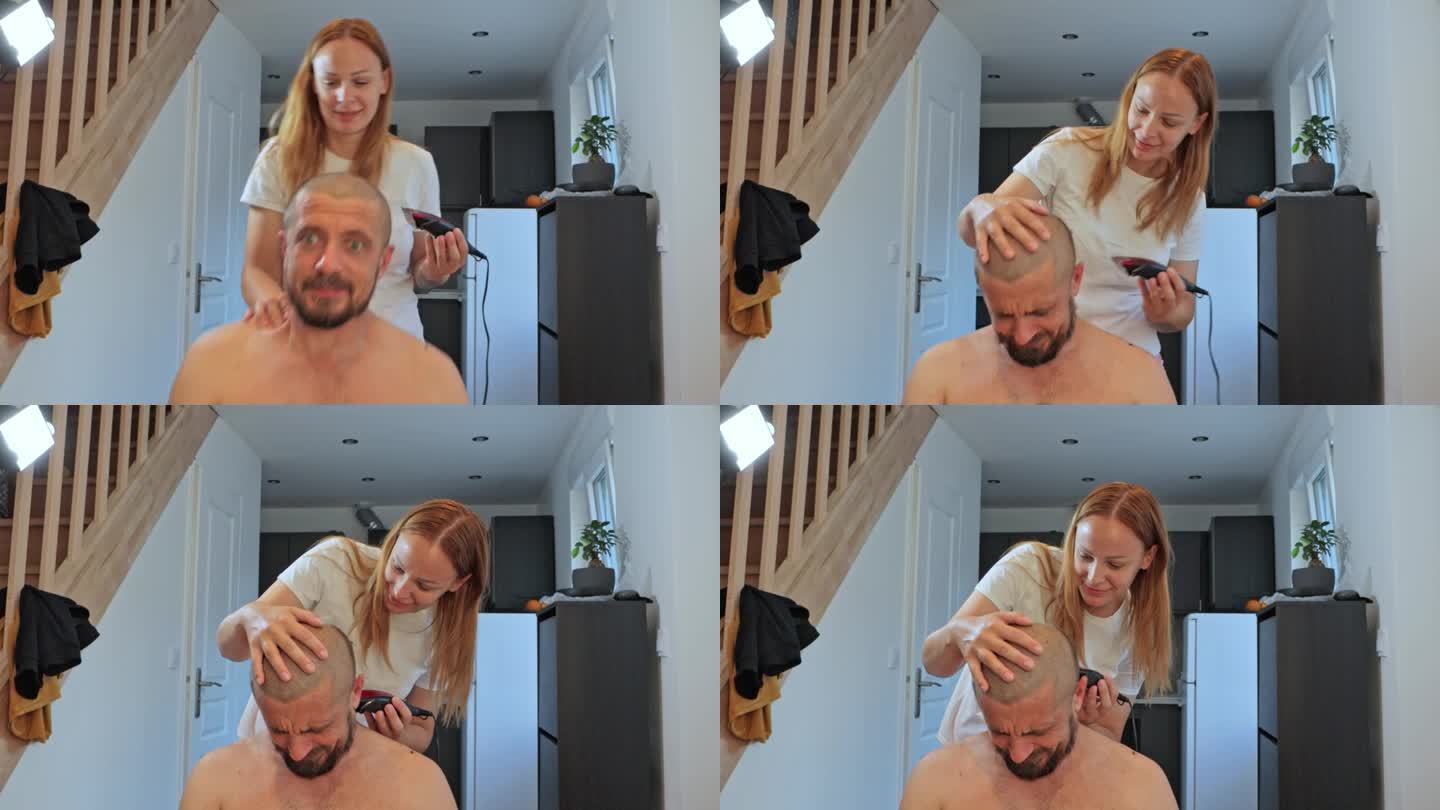 快乐的理发师抱着一个男人，用剪刀剪他的头发，男人坐在家里的厨房里。高品质4k画面