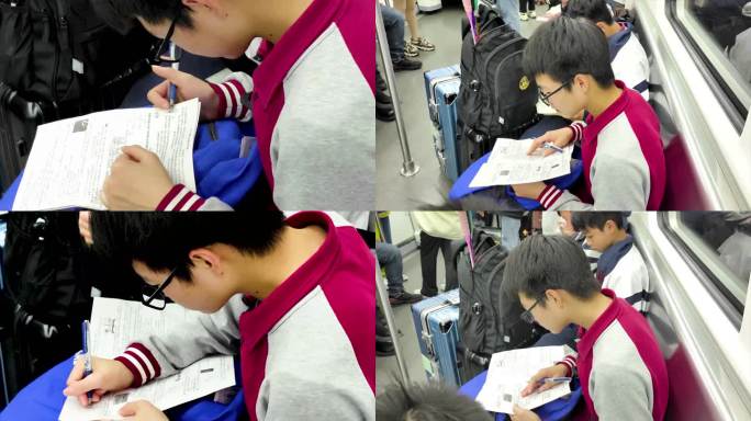 男孩在地铁上看书 写作业