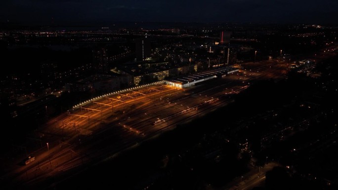 夜间火车站的航拍无人机视图。铁路站场、公路养护、交通运输及铁路基础设施。