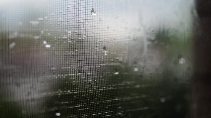 迷人的雨滴在下雨天优雅地从窗户倾泻而下，捕捉到宁静舒缓的氛围。