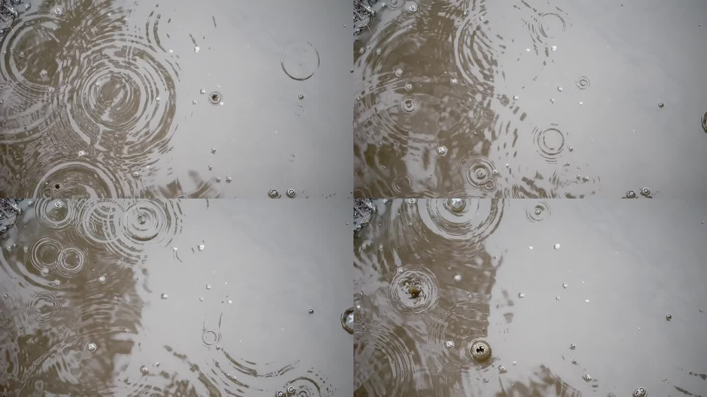 正上方:雨滴轻轻搅动水坑，慢镜头;泡沫升起，秋天的树木和天空在水中反射。