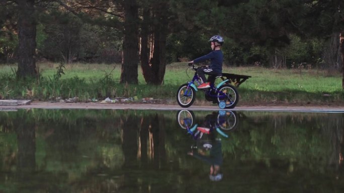 一个阳光明媚的秋日，一个小孩在湖边骑自行车