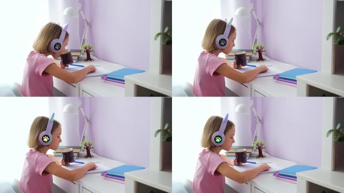 戴着耳机的小女孩在桌前做作业