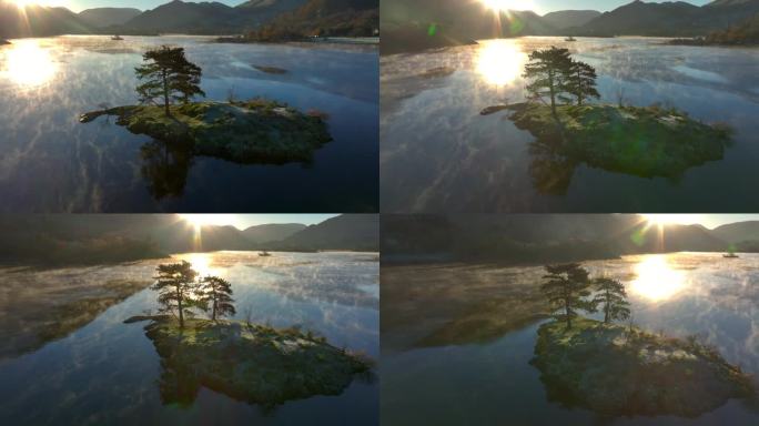 平静的湖面上的小岛，轻柔的薄雾在水面上盘旋，轨道上露出冉冉升起的太阳和被树木遮挡的反射。秋天。乌尔斯