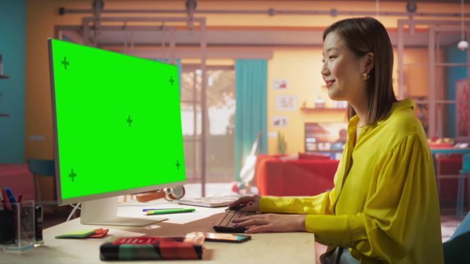 亚洲专业自由职业者工作在绿色屏幕个人电脑从家里。时尚女性浏览互联网，愉快地网购，在社交媒体上与朋友聊